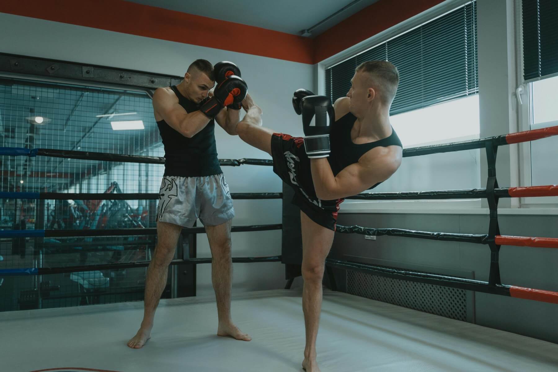 Doi sportivi practică tehnici de kickboxing
